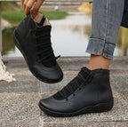 Black flat ankle boots with side zippers and front lacing, featuring a soft, rounded-toe leather-look design.