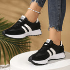 Black and white lace-up sneakers with striped side panels, thick soles, and "STAY REAL" tongue branding.