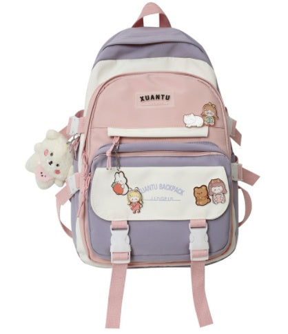 Pastel purple, pink, and white canvas backpack with cartoon charms, buckle closures, and multiple pockets.
