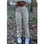 High-waisted beige cargo pants with side pockets and button details, styled in a trendy, fitted workwear design.