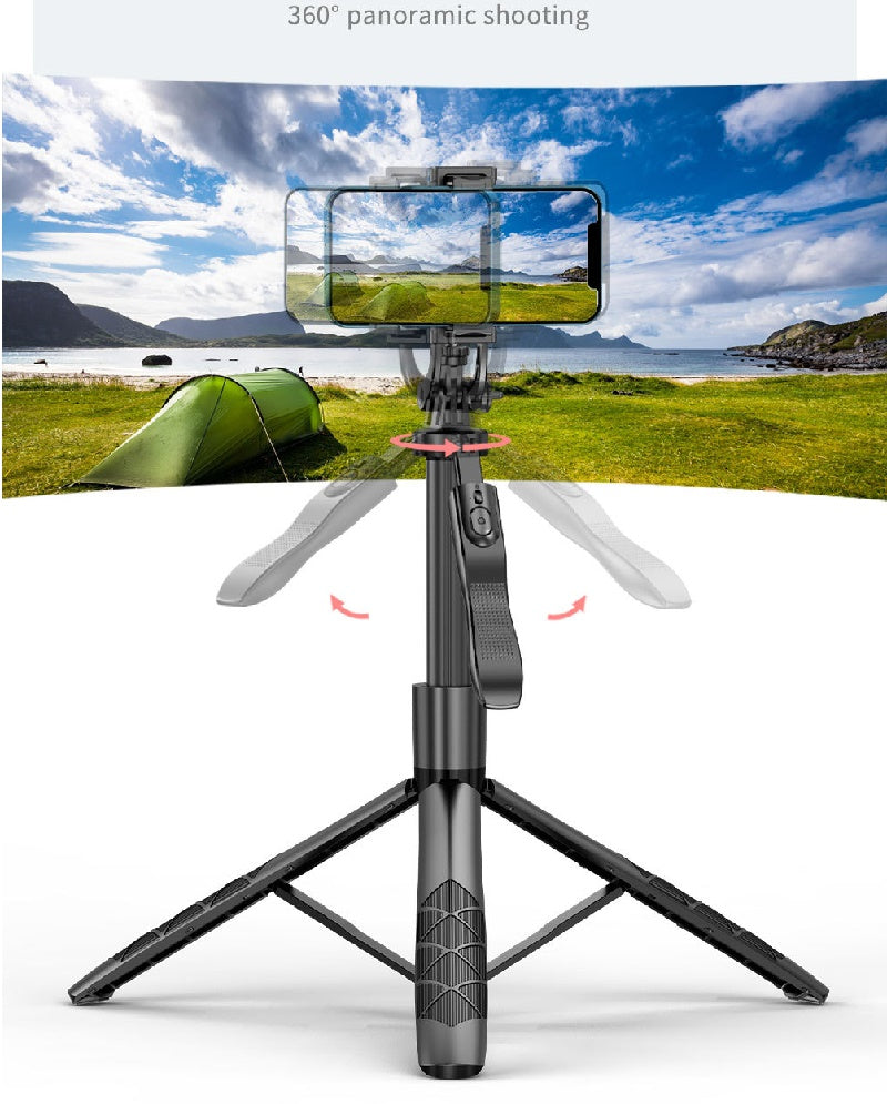 Black 360-degree auto-tracking phone tripod with foldable legs and a mounted smartphone filming a panoramic landscape.