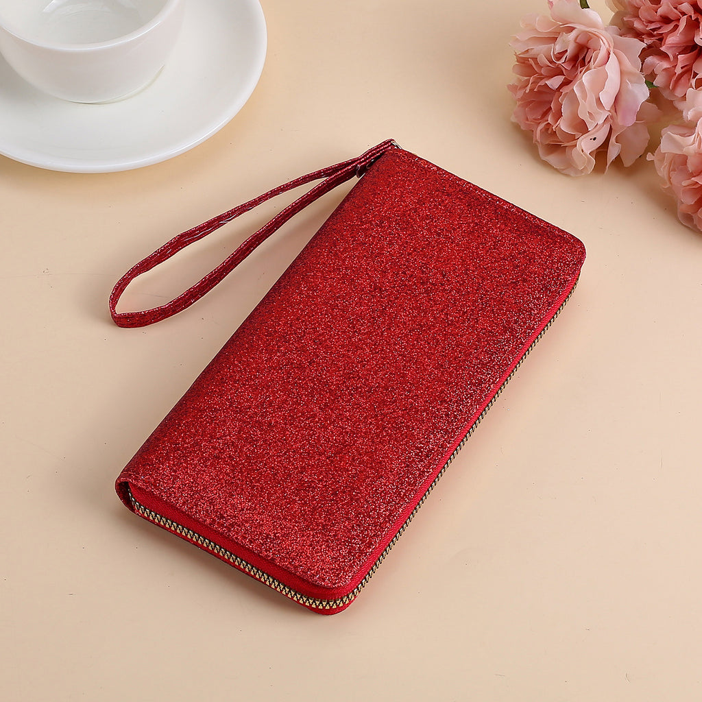 A shiny red glitter clutch for women with a wrist strap and gold zipper closure, set against a light background.