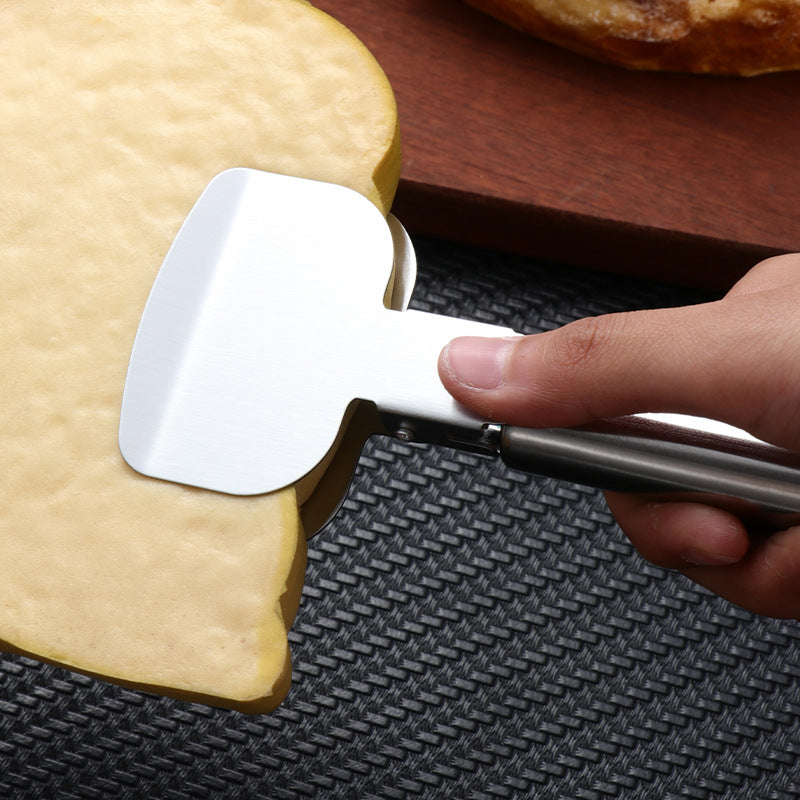 Hand holding a silver stainless steel pizza cutter pressing into a light brown crust on a black textured mat.
