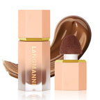 Langmanni liquid contour bottle and sponge applicator in soft peach with a dark brown liquid swatch background.