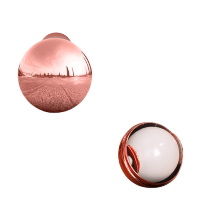 A rose gold reusable pet hair remover ball with a sticky white inner gel core for cleaning clothes.