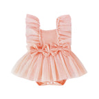 Peach-colored baby jumpsuit with frilly tulle trim, two front bows, and a snap-button bottom.