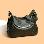 Dark green soft leather shoulder bag with a curved silver accent, adjustable strap, and a small kangaroo metal logo.