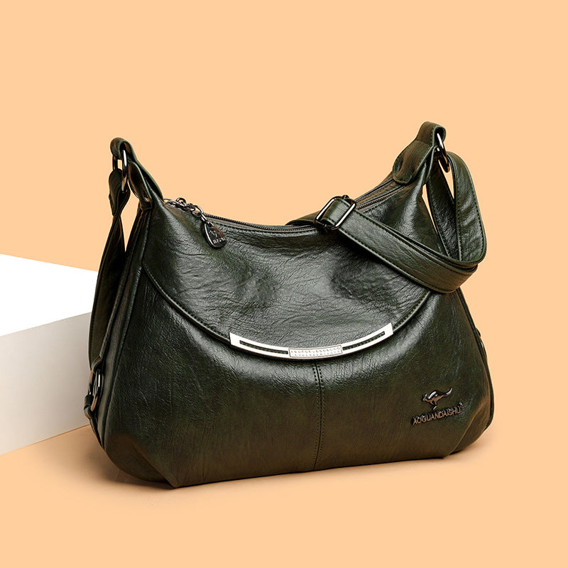 Dark green soft leather shoulder bag with a curved silver accent, adjustable strap, and a small kangaroo metal logo.