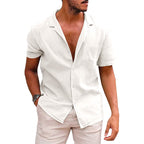 Model wearing a short-sleeve, white linen-style button-down shirt with an open camp collar for a casual beach look.