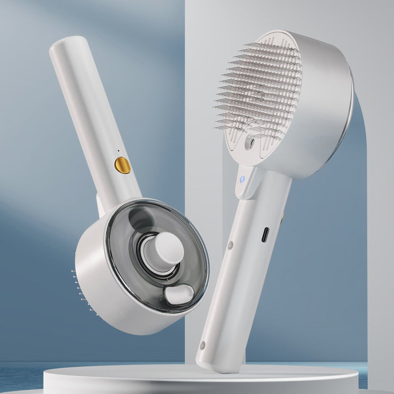 White steam pet grooming brush with fine metal bristles, gold button, and water tank on a white cylindrical stand.