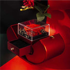 Red apple-shaped jewelry box with an eternal red rose in a clear case and a velvet-lined pull-out drawer.