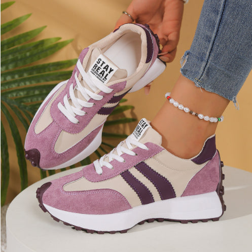 Women's mauve and beige suede lace-up sneakers with purple stripes, white chunky soles, and "STAY REAL" tongue labels.