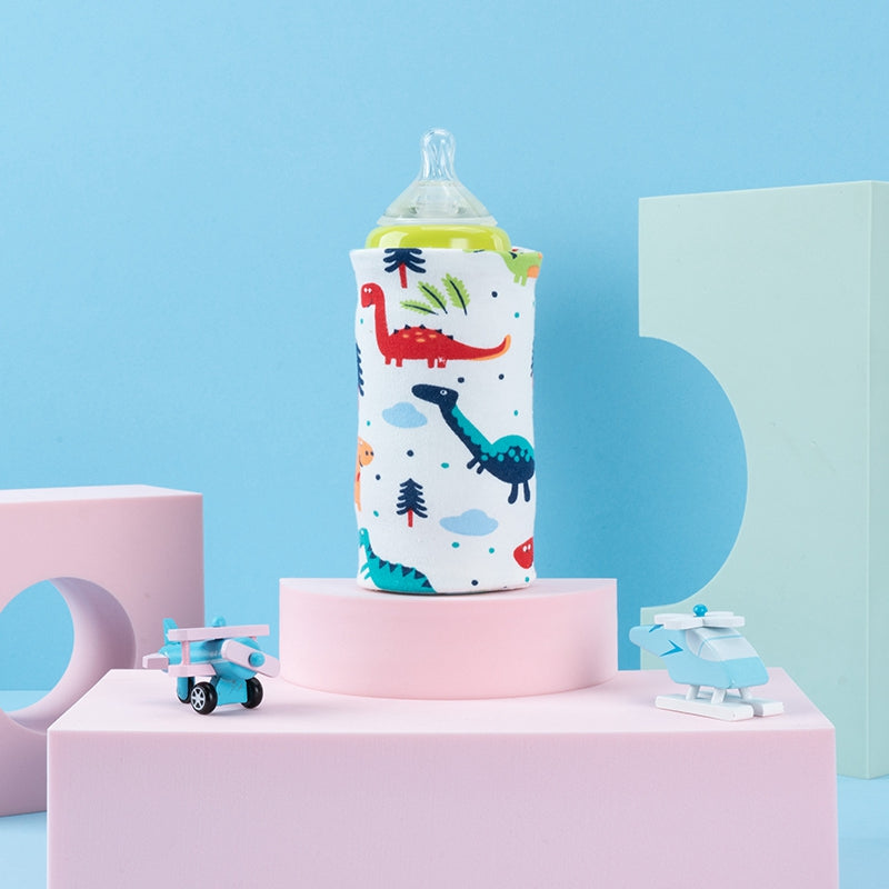Portable USB baby bottle warmer sleeve in a white fabric with colorful dinosaur and tree prints.