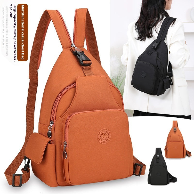 Orange waterproof nylon chest backpack with multiple pockets, zipper closures, and adjustable straps for casual use.