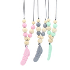 Three silicone feather teether necklaces with wooden and pastel silicone beads on black cords against a white background.