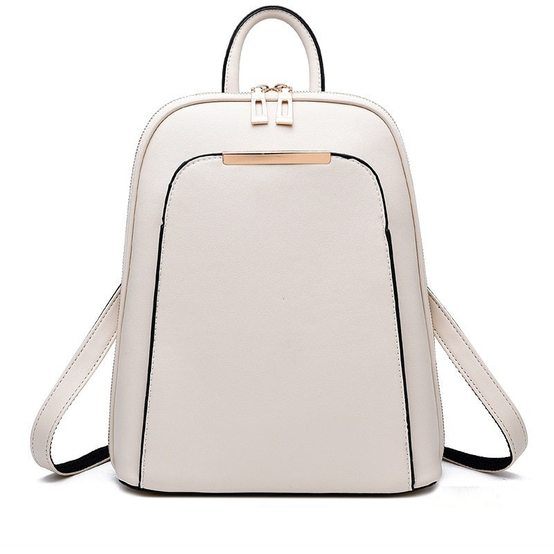 Minimalist cream leather backpack with top handle, dual zippers, and metallic front accent.
