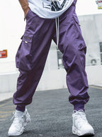 Purple cargo pants with side pockets, drawstring waist, and elastic cuffs in a baggy, hip-hop streetwear style.