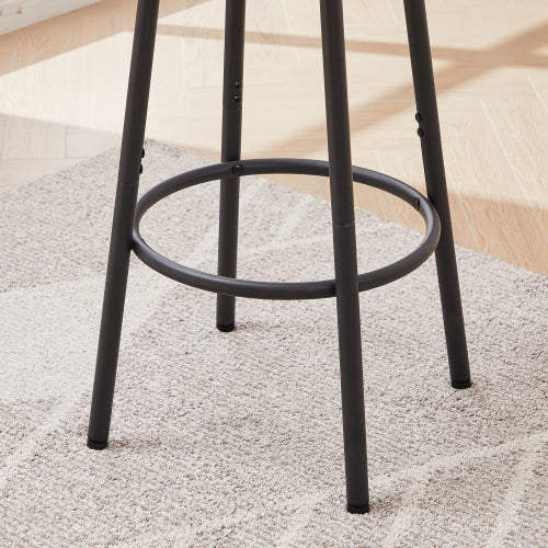Matte black metal bar stool legs with a circular footrest ring, standing on a light-colored textured rug.