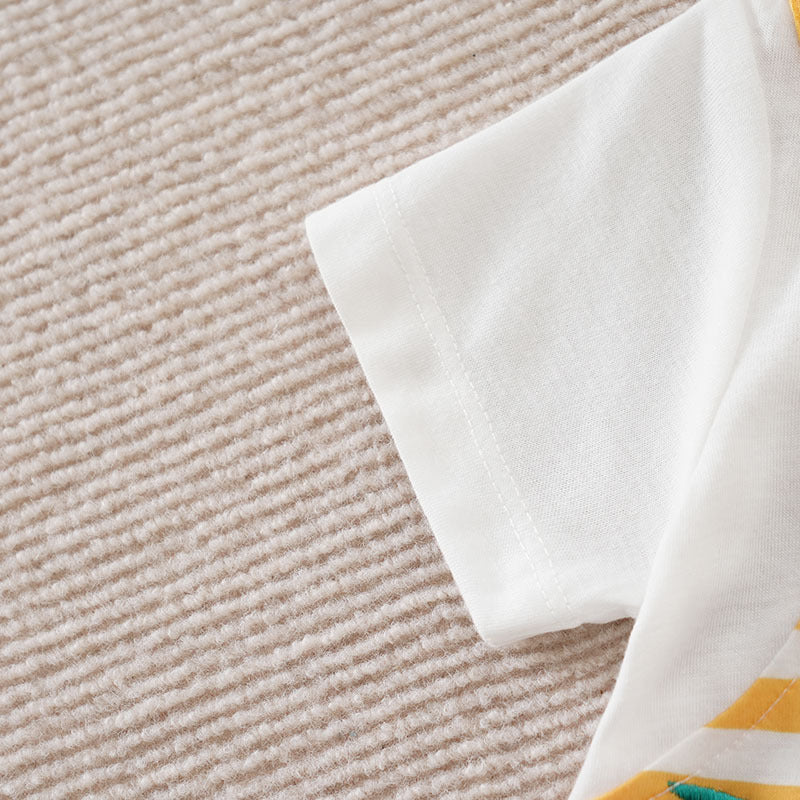 White short-sleeve baby jumpsuit with yellow and green striped detailing on a textured beige background.