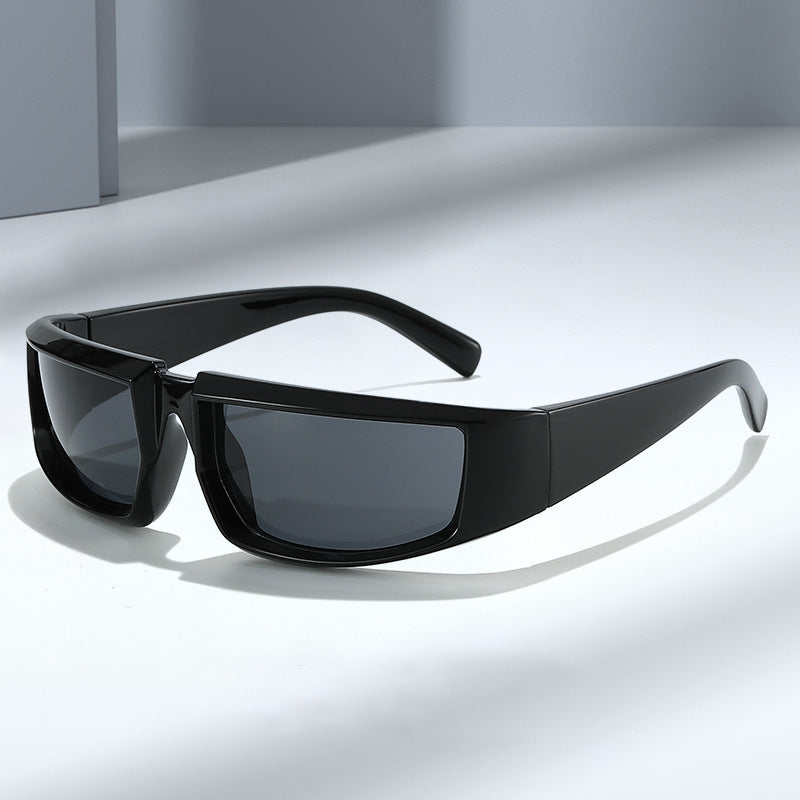 Glossy black hip-hop sports sunglasses with rectangular frames and dark, protective lenses on a neutral gray surface.