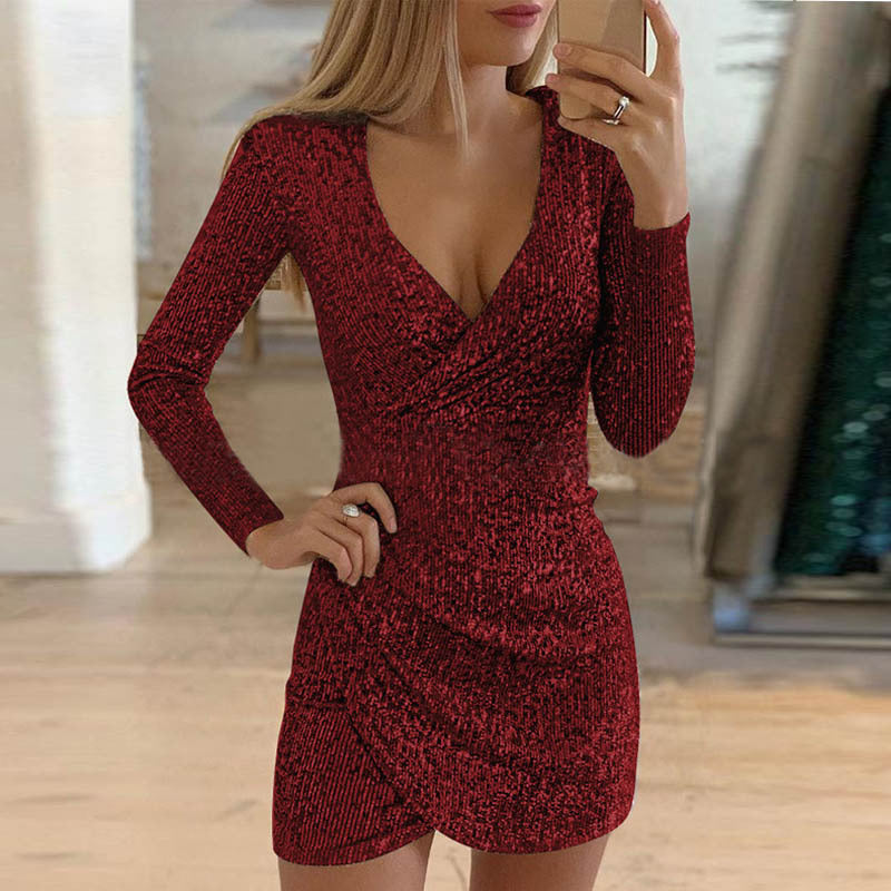 A woman wears a long-sleeved, glittery red V-neck mini dress with an irregular wrap-style skirt.