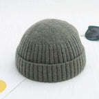 Olive green, ribbed knit beanie cap with a cuffed brim, featuring a soft, fuzzy texture.