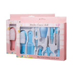 Blue and pink baby care kit in a gift box, including a digital thermometer, brush, comb, scissors, and nail file.