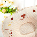 Beige corduroy baby pillow with embroidered animal face, center head support, and soft textured fabric.