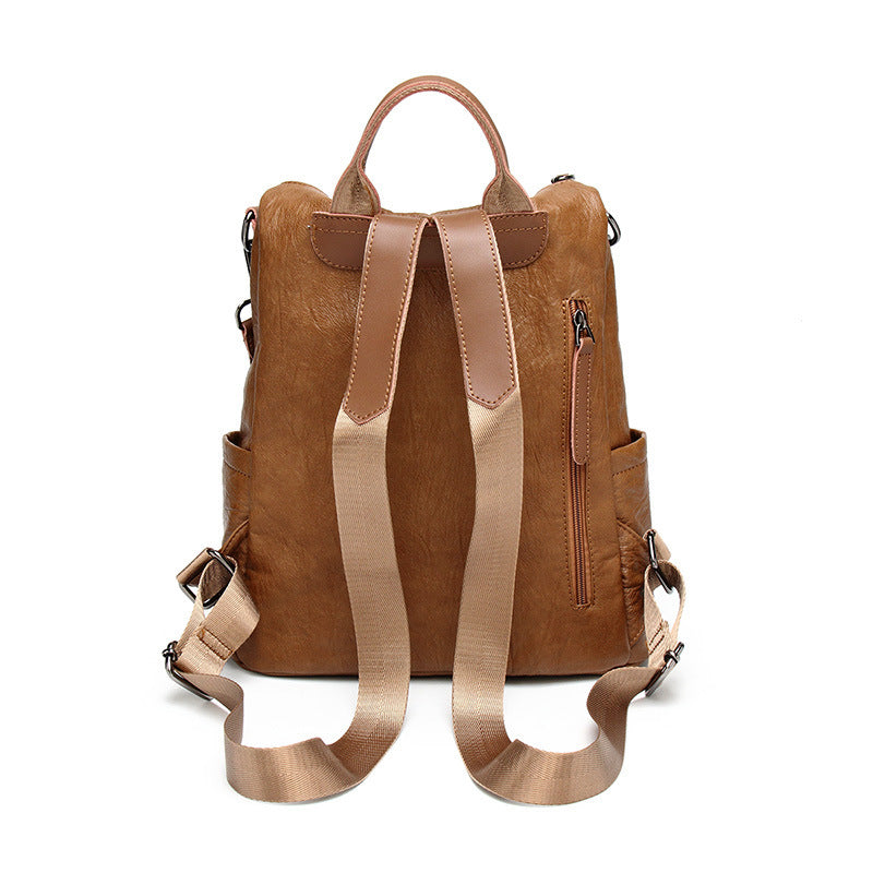 Back view of a tan, soft leather multifunctional backpack with adjustable nylon straps and a vertical side zipper pocket.