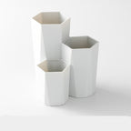 White, three-tiered hexagonal plastic makeup brush storage organizer.