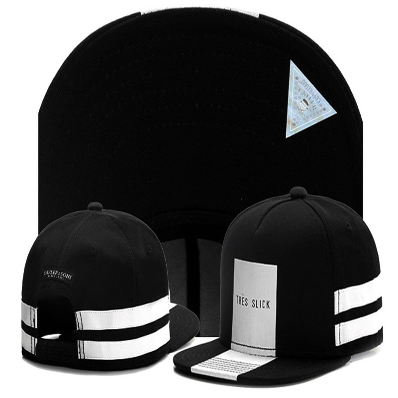 Black snapback hat with white "TRÈS SLICK" front patch, side stripes, and a holographic triangle authentication sticker.