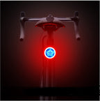 Round USB bicycle taillight mounted on a seat post, featuring a bright blue star-shaped LED light with a red halo.