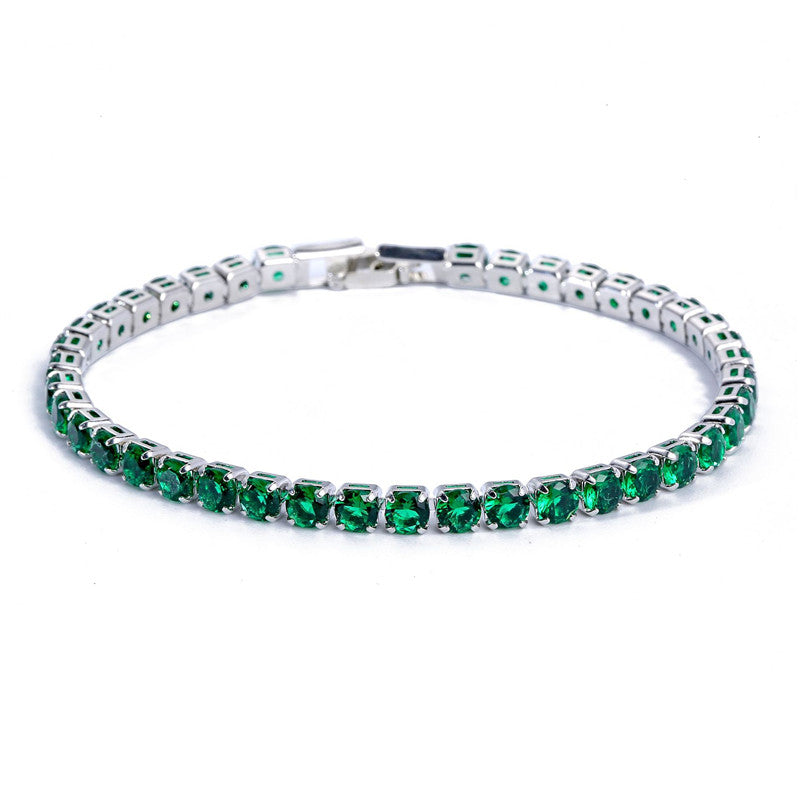 Silver-tone tennis bracelet featuring a single row of round, micro-inlaid emerald green zircon stones.