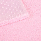 Soft pink baby blanket with a raised polka dot texture on one side and a plush, fuzzy fleece material on the other.