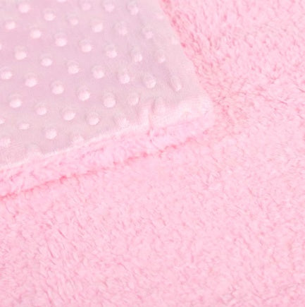 Soft pink baby blanket with a raised polka dot texture on one side and a plush, fuzzy fleece material on the other.