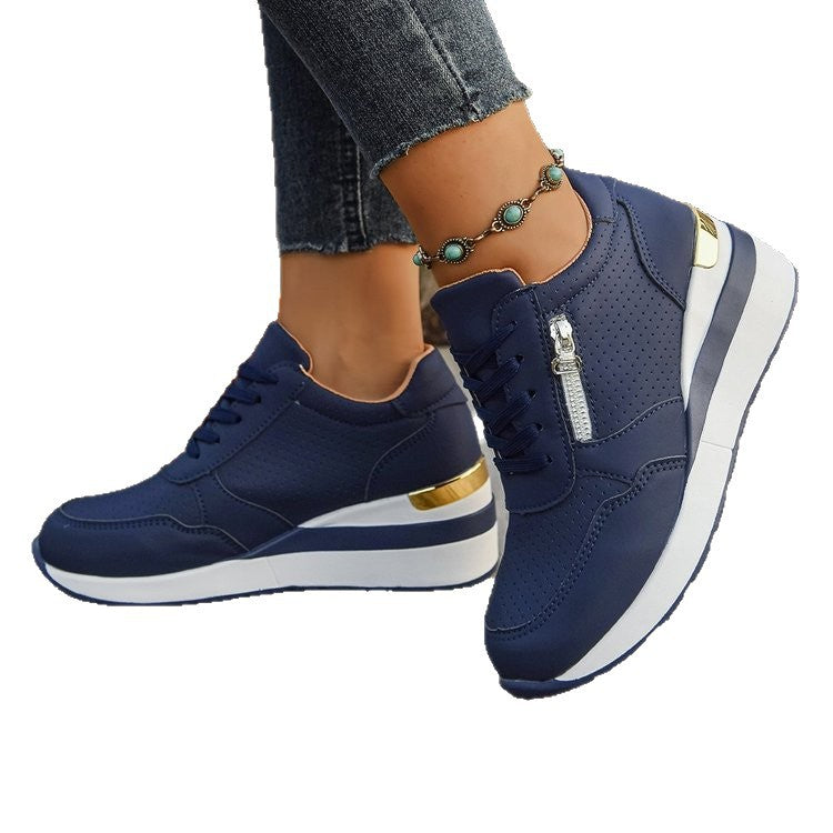 Navy blue perforated athletic sneakers with side zippers, lace-up fronts, and white platform soles with gold accents.