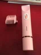 A pink, slender electric hair trimmer with a gold power button and a matching detachable plastic guide comb.