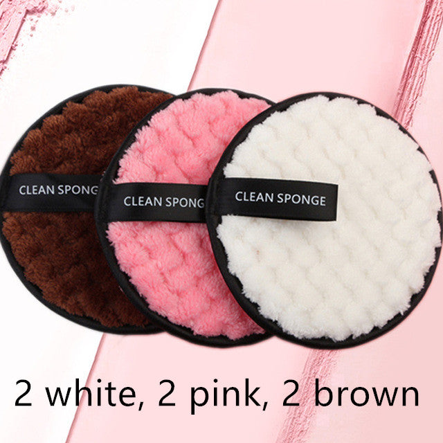 Three round, textured microfiber makeup remover puffs in brown, pink, and white with black "CLEAN SPONGE" finger straps.