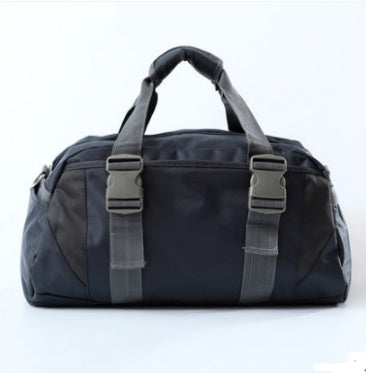 Black nylon gym bag featuring dual-tone grey straps and two front quick-release buckles against a white background.