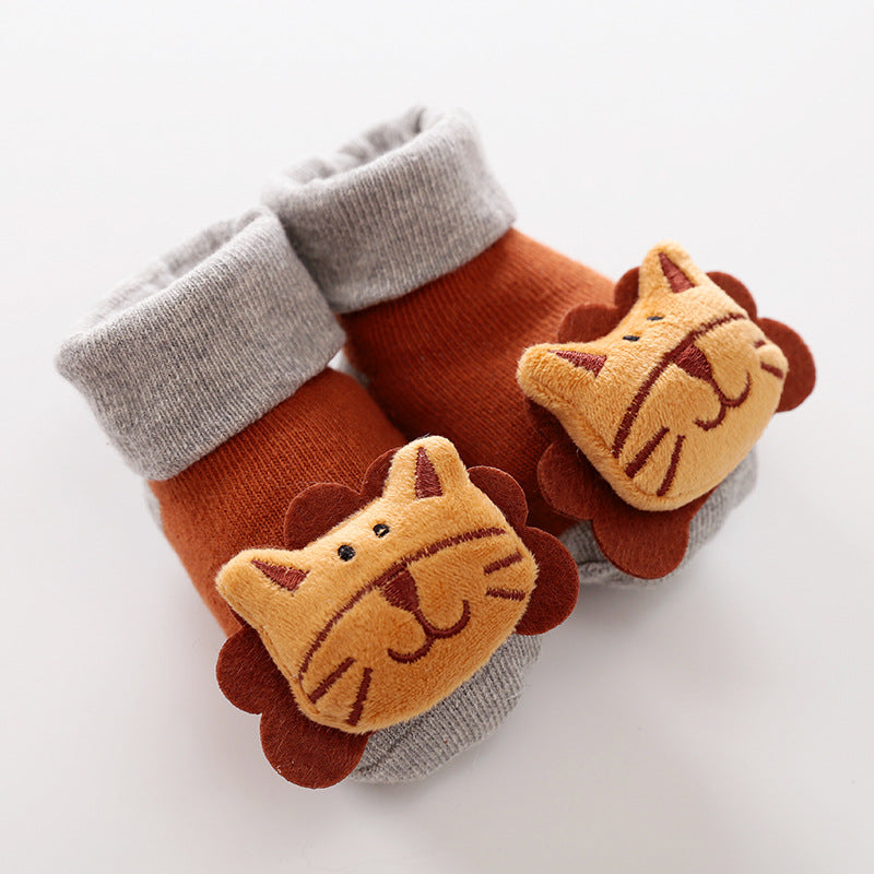 Rust and grey baby socks featuring plush 3D lion face appliques on the front, made of soft knit fabric.