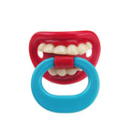 Funny baby pacifier with a red mouth, white teeth design, and a bright blue ring handle on a white background.