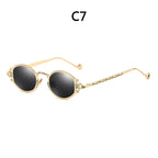 Gold-tone steampunk sunglasses with round black lenses, featuring intricate filigree metal frames and temple arms.