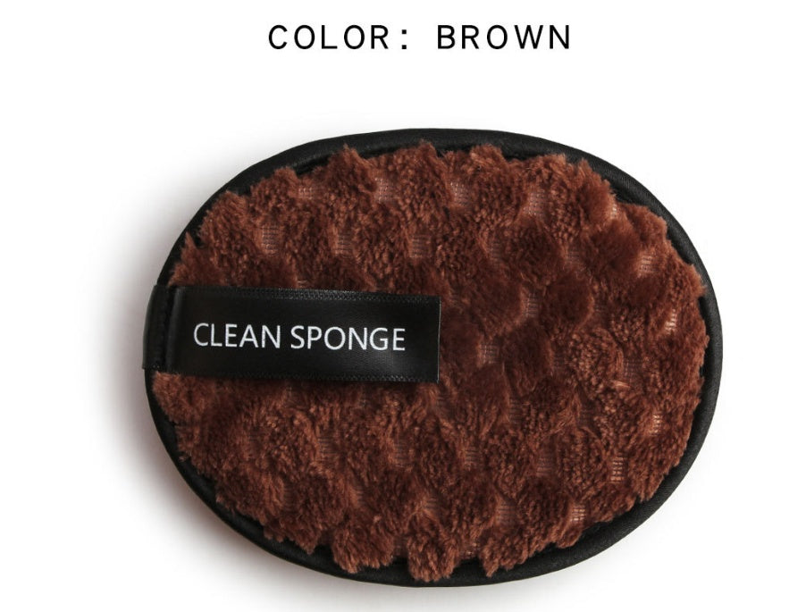 Oval brown textured microfiber makeup cleansing sponge with a black trim and "CLEAN SPONGE" label on a white background.