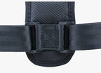 Black textile posture corrector strap with adjustable plastic buckles and padded mesh center panel on white background.