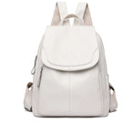 White soft leather backpack with a flap top, zip closure, and comfortable shoulder straps. Casual, minimalist style.