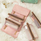 Pink 4-in-1 travel storage organizer with detachable mesh bags for toiletries and makeup on a white fur background.