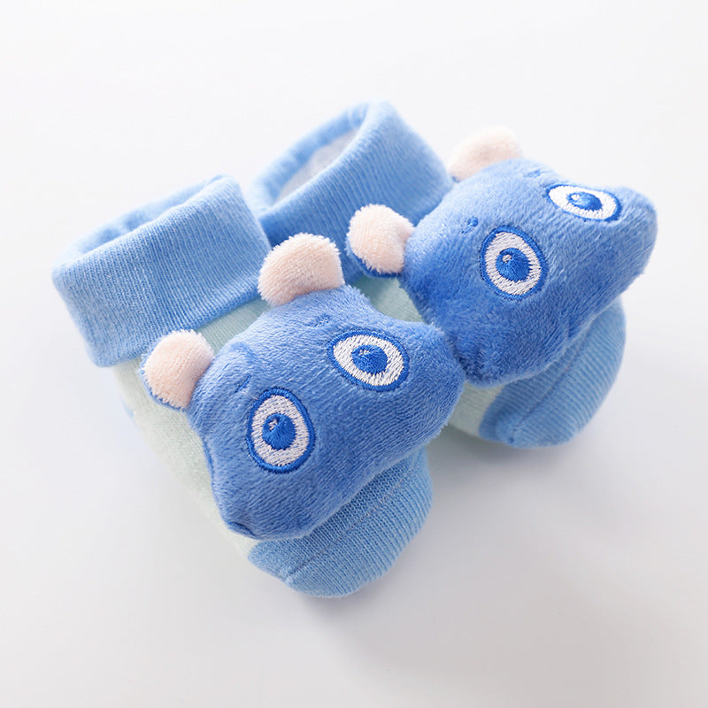 Soft blue baby socks featuring plush, smiling hippo faces with embroidered eyes and small ears on a light background.
