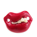 A glossy red plastic pacifier shaped like puckered lips biting down on white plastic teeth, isolated on white.