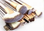 A set of 24 makeup brushes with gold handles and white-tipped bristles arranged on a white background.