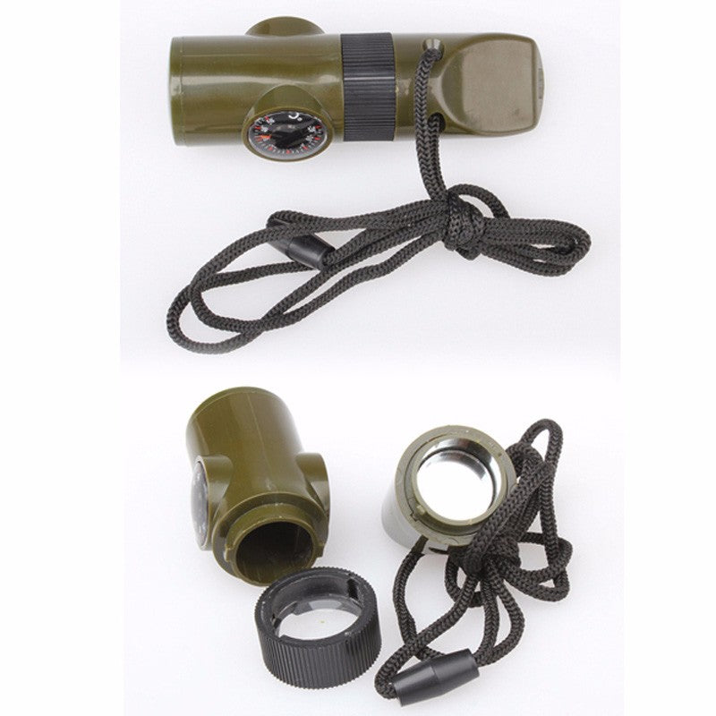 Olive green 7-in-1 plastic survival whistle with integrated compass, mirror, and magnifying glass on a black lanyard.